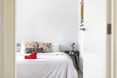 a bedroom with a white bed with a red bow on it at Casa Familiar 9 Pax, Smart TV, Centro, Playa, Café, AC in Valencia