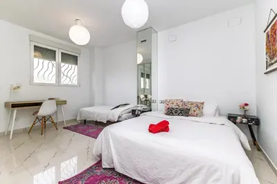 a white bedroom with two beds and a mirror at Casa Familiar 9 Pax, Smart TV, Centro, Playa, Café, AC in Valencia