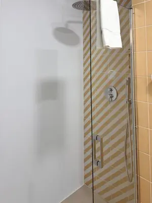 a shower with a glass door in a bathroom at Exclusive beachfront apartment in Valencia
