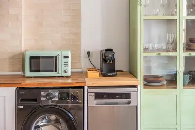 a kitchen with a washing machine and a microwave at Luxury new apartment 10 min walk to the beach, Late Checkout in Valencia