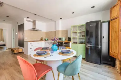 a kitchen with a table with chairs and a refrigerator at Luxury new apartment 10 min walk to the beach, Late Checkout in Valencia