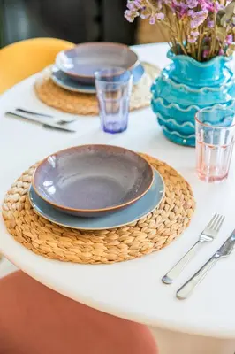 a table set with plates and a blue vase at Luxury new apartment 10 min walk to the beach, Late Checkout in Valencia