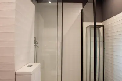 a bathroom with a toilet and a glass shower at Luxury new apartment 10 min walk to the beach, Late Checkout in Valencia