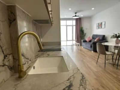 a kitchen with a sink and a living room at La fonda de Olympia in Valencia