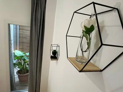 a mirror hanging on a wall next to a window with a vase at La fonda de Olympia in Valencia