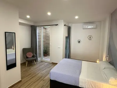 a bedroom with a bed and a chair and a window at La fonda de Olympia in Valencia