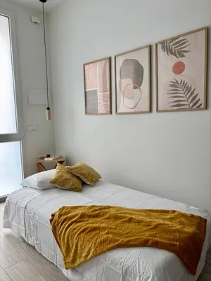 a bedroom with a bed with three pictures on the wall at Apartamento en Valencia Ruzafa in Valencia