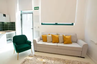 a living room with a couch and a green chair at Apartment 1 City of Arts and science Fast Wifi 1 in Valencia