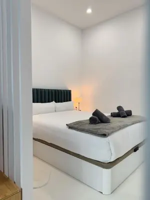 a white bed in a white room with two pillows on it at Apartment 1 City of Arts and science Fast Wifi 1 in Valencia
