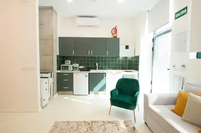 a kitchen with a couch and a green chair in a room at Apartment 1 City of Arts and science Fast Wifi 1 in Valencia