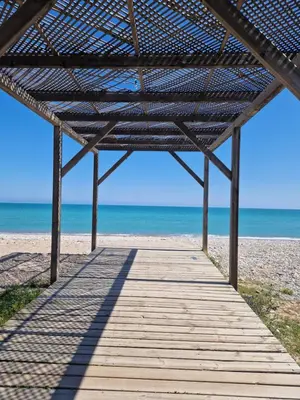 a boardwalk on the beach with the ocean in the background at La Luz de Lucia in Moncófar
