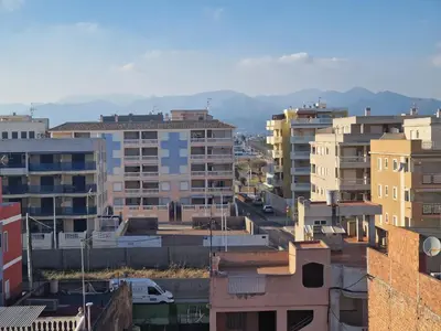 a city with buildings and mountains in the background at La Luz de Lucia in Moncófar