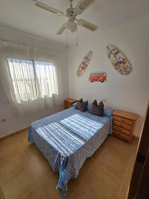 a bedroom with a bed and a ceiling fan at Relax en familia junto al mar Les Palmeres in Sueca