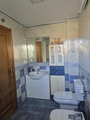 a bathroom with a sink and a toilet and a mirror at Relax en familia junto al mar Les Palmeres in Sueca