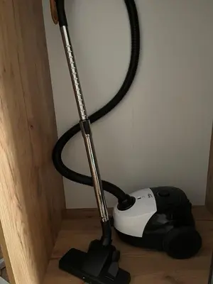 a black and white vacuum cleaner sitting next to a wall at Apartament Marina Cullera in Cullera