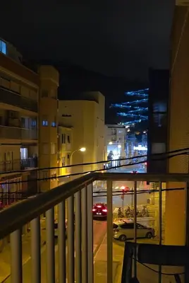 a view of a city at night from a balcony at Apartament Marina Cullera in Cullera