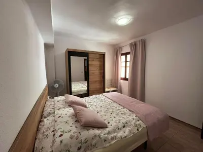 a bedroom with a bed with pillows and a mirror at Apartament Marina Cullera in Cullera