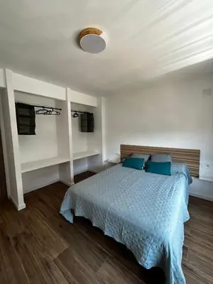 a bedroom with a bed with blue pillows at Vistas del Frailecico in Chulilla