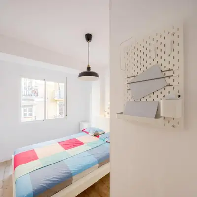 a white bedroom with a bed and a window at GuestReady - Homely escape in Valencia in Valencia