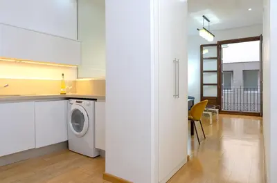 a kitchen with a washing machine in a white kitchen at Grand Central Market Suites By VALENCIAFLATS EU in Valencia