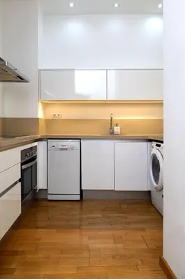 a kitchen with white cabinets and a washer and dryer at Grand Central Market Suites By VALENCIAFLATS EU in Valencia