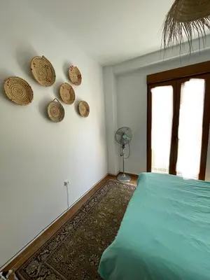 a bedroom with a bed and a window and a fan at Charming fisherman's house Cabanyal Cabañal in Valencia