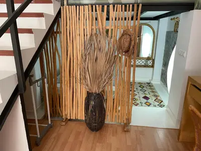 a vase with grass in it sitting on a floor at Charming fisherman's house Cabanyal Cabañal in Valencia