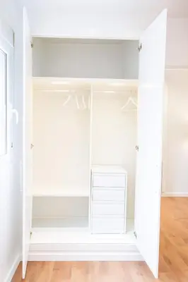 a closet with white cabinets and a wooden floor at El Pilar Luxury Suites By VALENCIAFLATS EU in Valencia