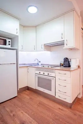 a kitchen with white cabinets and white appliances at El Pilar Luxury Suites By VALENCIAFLATS EU in Valencia