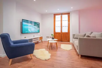a living room with a couch and a tv at El Pilar Luxury Suites By VALENCIAFLATS EU in Valencia