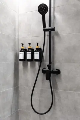 a shower with four bottles of soap in a bathroom at Tao Suite 2 next to the Aquarium in Valencia