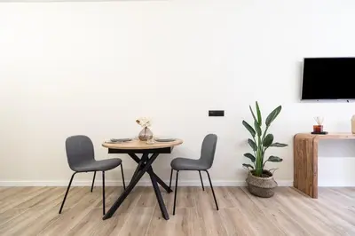 a table and chairs in a room with a tv at Tao Suite 2 next to the Aquarium in Valencia