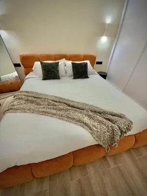 a large bed with white sheets and pillows at Tao Suite 2 next to the Aquarium in Valencia