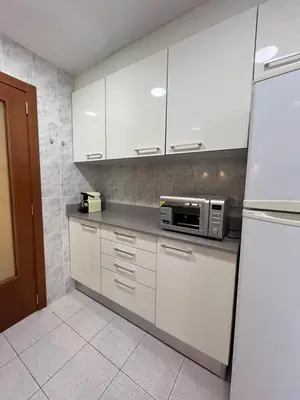 a kitchen with white cabinets and a microwave at Apartamento Torres Serranos in Valencia