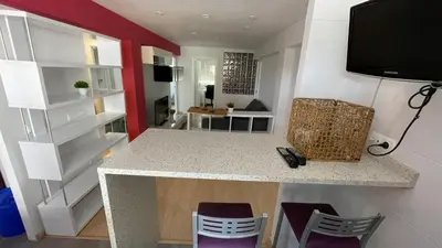 a kitchen with purple chairs and a counter with a tv at Flat close to beach perfect for families and groups - Isidro B 3 in Valencia