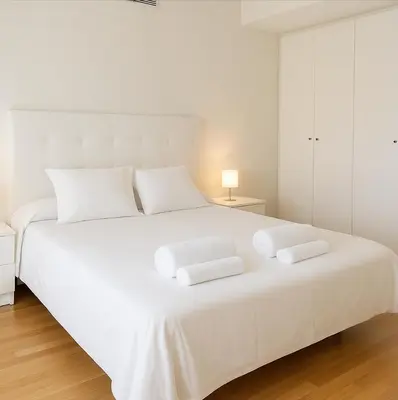 a white bedroom with a large white bed with two pillows at Panoramic Suites By VALENCIAFLATS EU in Valencia