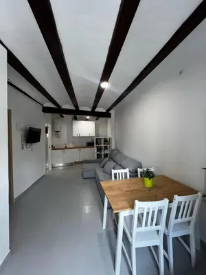 a living room with a wooden table and white chairs at Piso 1 - Apartamento Mercado Central in Valencia