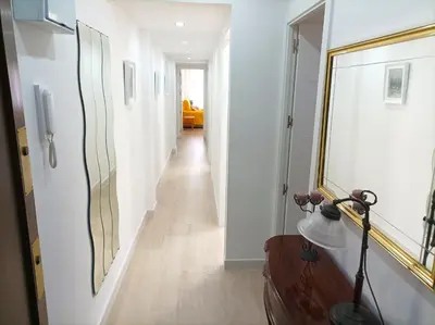 a hallway with white walls and a mirror on the wall at Marti, 7-38 in Cullera