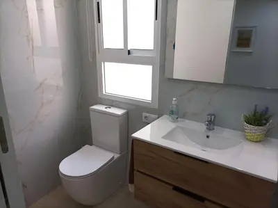 a bathroom with a toilet and a sink and a window at Marti, 7-38 in Cullera