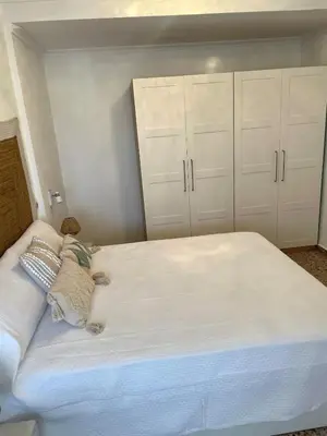 a bedroom with a large white bed with white cabinets at Apartment on Sueca Beach Mis Gaviotas in Mareny Barraquetas