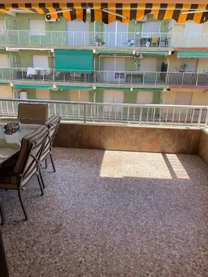 a balcony of a building with a table and chairs at Apartment on Sueca Beach Mis Gaviotas in Mareny Barraquetas