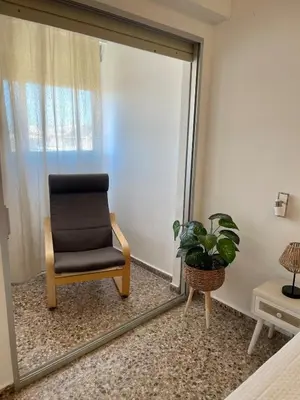 a mirror in a room with a chair and a plant at Apartment on Sueca Beach Mis Gaviotas in Mareny Barraquetas