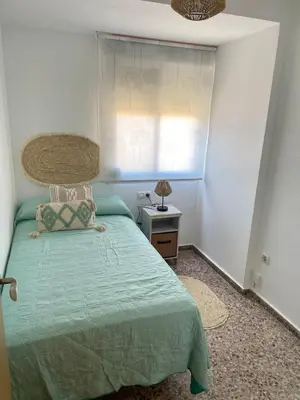 a bedroom with a green bed and a window at Apartment on Sueca Beach Mis Gaviotas in Mareny Barraquetas