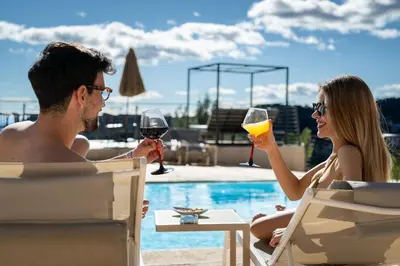 a man and woman sitting at a table with glasses of wine at Resort Serra Nature - Luxury Villas Hotel Boutique in Serra