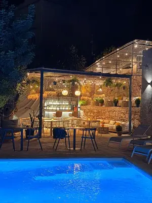 a patio with a table and a pool at night at Resort Serra Nature - Luxury Villas Hotel Boutique in Serra