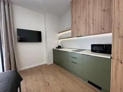 a kitchen with green cabinets and a microwave at Apartamentos Nou Mestalla in Valencia