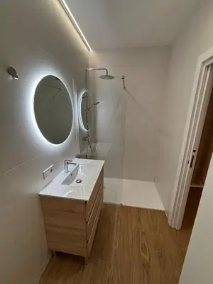 a white bathroom with a sink and a mirror at Apartamentos Nou Mestalla in Valencia