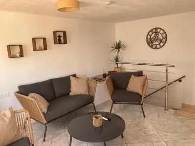 a living room with two couches and a table at La Terracita de Carrica in Peñalba
