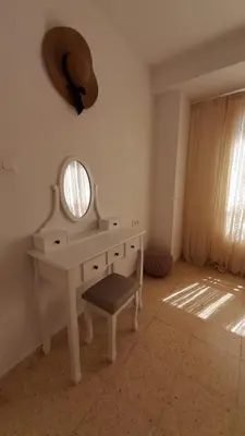a dressing table with a mirror and a chair in a room at La Terracita de Carrica in Peñalba