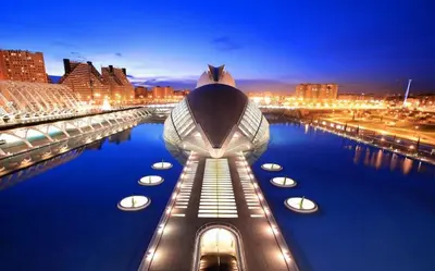 a building with boats in a river at night at Resort & Suites Ciudad de las Ciencias By VALENCIAFLATS EU in Valencia